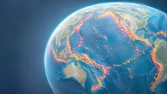 Scientific illustration of the globe with plate boundaries traced as glowing belts of earthquake activity around the Pacific and along the mid-ocean ridges.