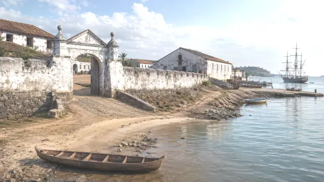 Reconstruction of a West African coastal trading fort: whitewashed walls and a seaward gate above the beach, with a ship anchored offshore.